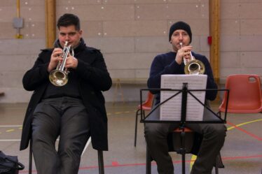 Deux trompettistes en formation, assis avec partitions