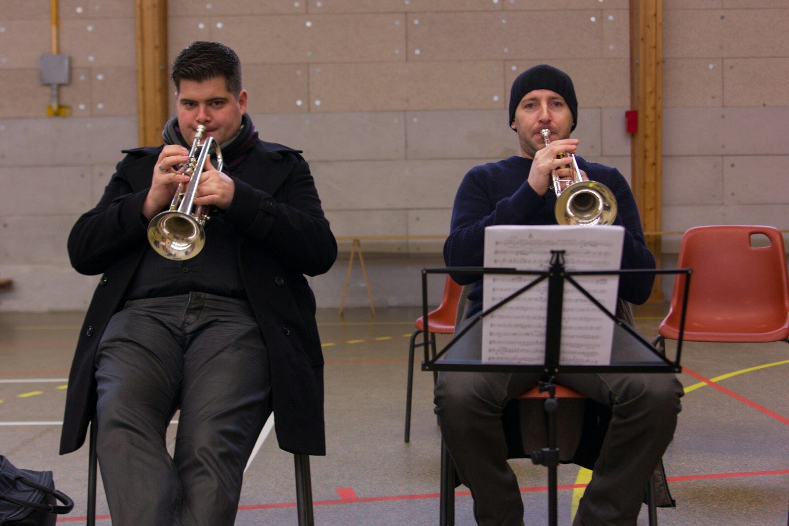 Deux trompettistes en formation, assis avec partitions