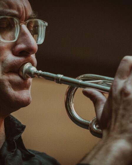 Trompettiste avec lunettes jouant en intérieur