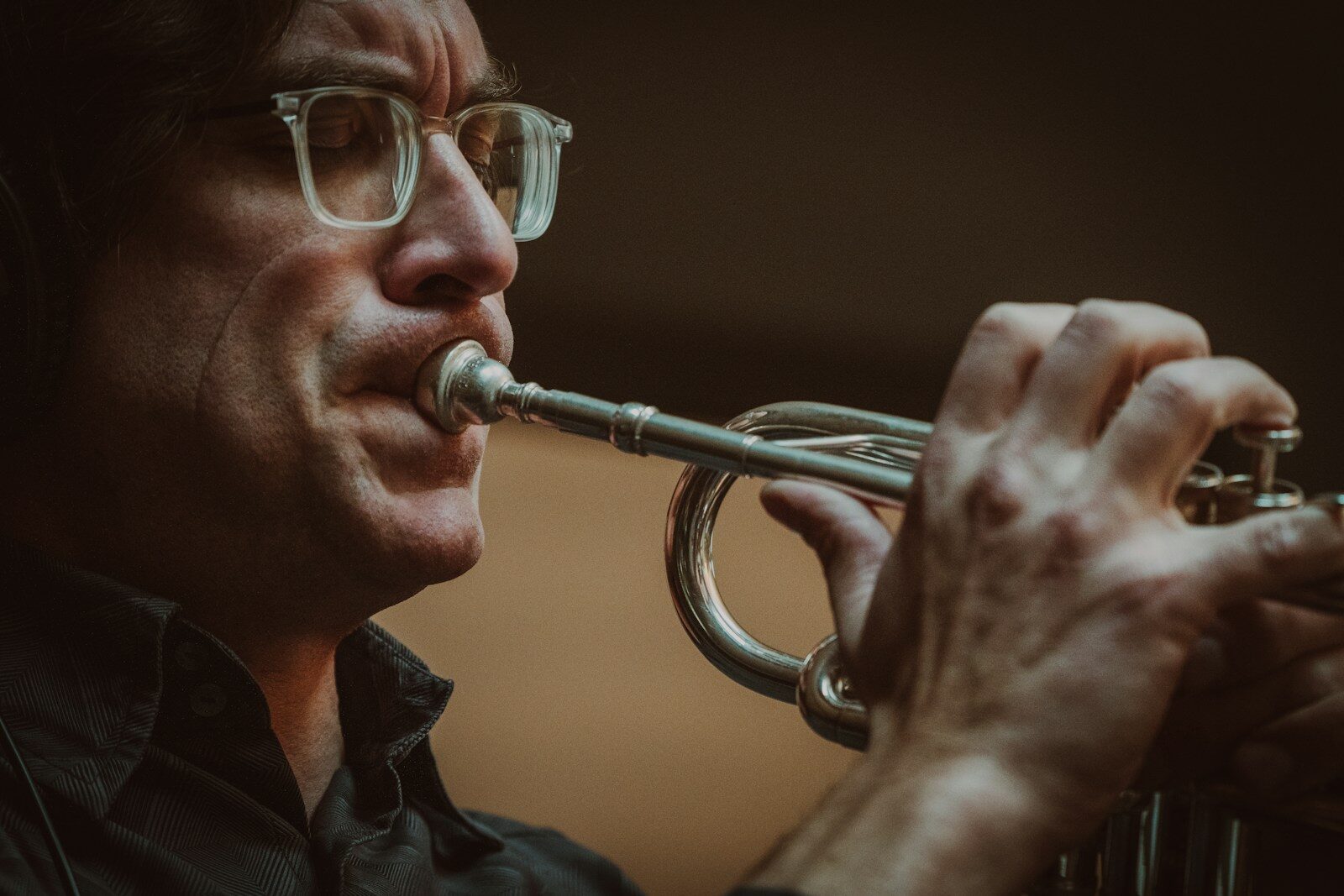 Trompettiste avec lunettes jouant en intérieur