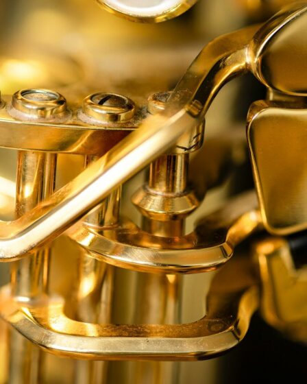 Gros plan doré sur l’embouchure et les pistons d’une trompette