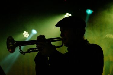 Silhouette d’un trompettiste sous une lumière verte