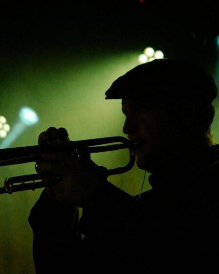 Silhouette d’un trompettiste sous une lumière verte