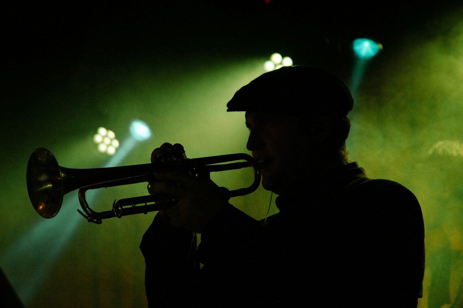 Silhouette d’un trompettiste sous une lumière verte