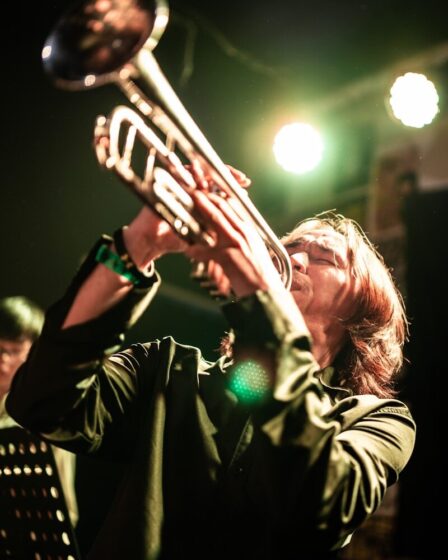 Trompettiste jouant intensément en concert sous les projecteurs