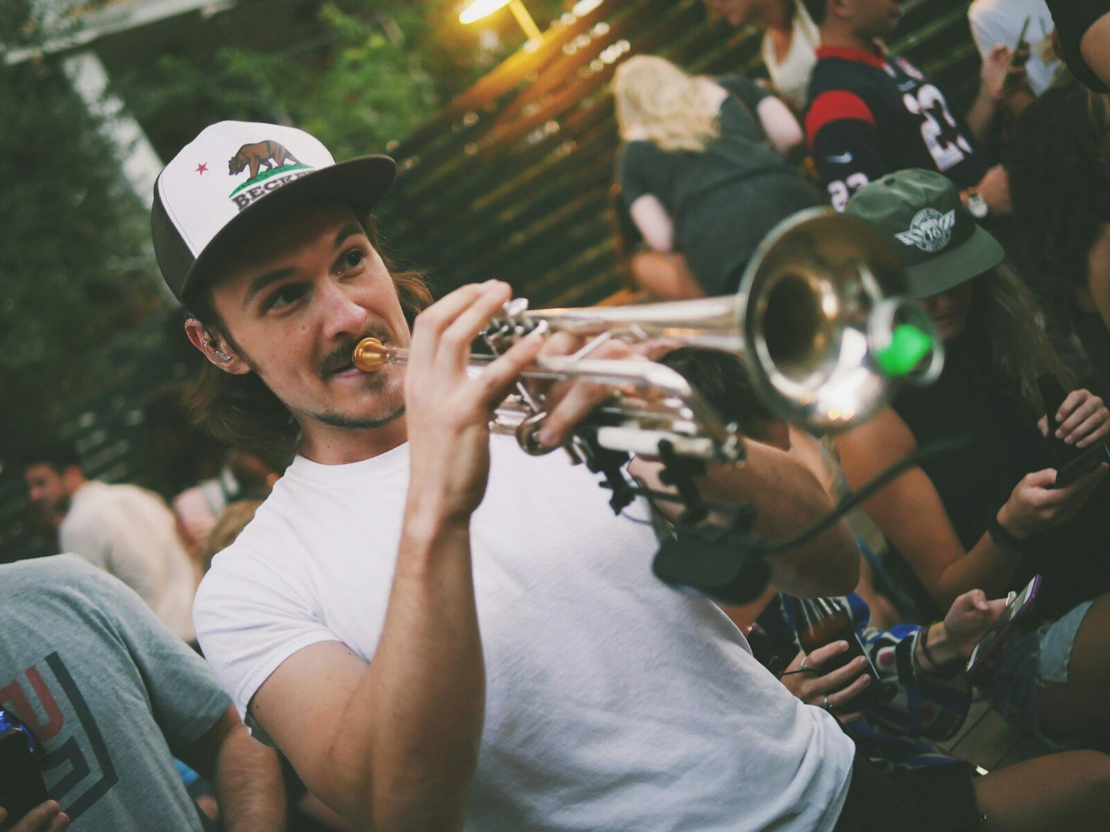 Jeune trompettiste filmé par la foule lors d’un concert