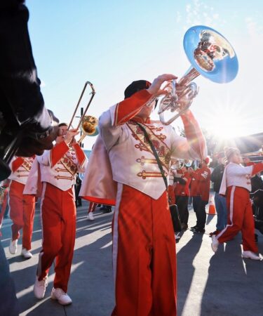 Fanfare de cuivres défilant en costumes traditionnels dans la rue lors d'un festival populaire