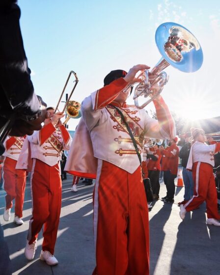 Fanfare de cuivres défilant en costumes traditionnels dans la rue lors d'un festival populaire
