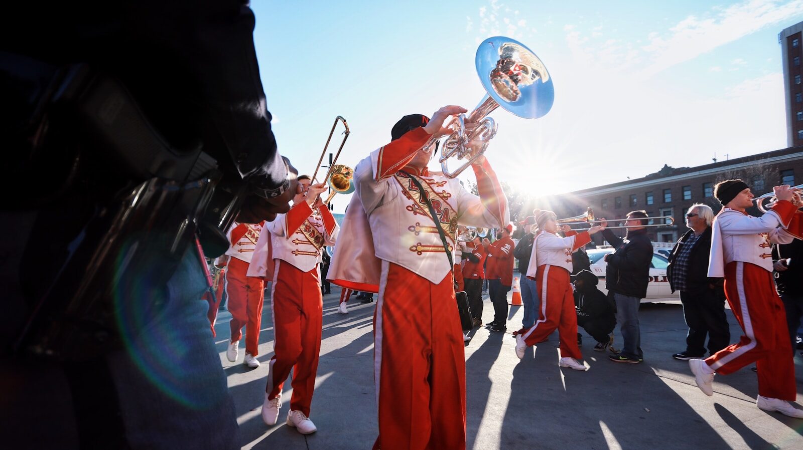 Fanfare de cuivres défilant en costumes traditionnels dans la rue lors d'un festival populaire